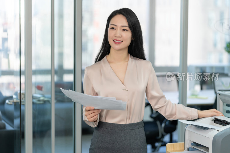 年轻商务女士使用打印机