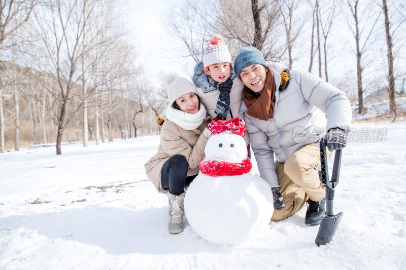 一家三口在雪地里堆雪人