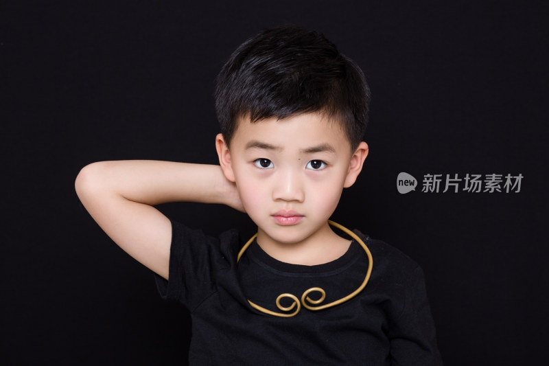 黑色背景下可爱的中国小男孩肖像