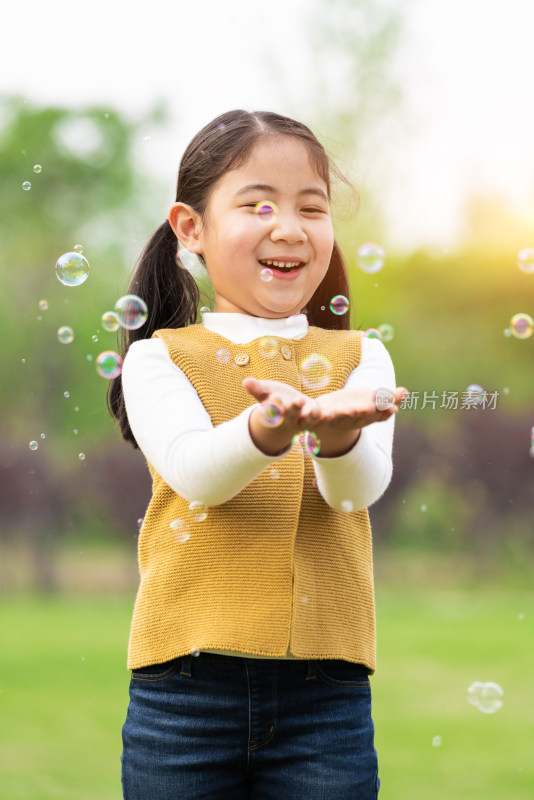 在草坪上玩泡泡游戏的女孩