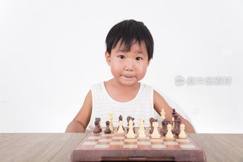 国际象棋棋盘前看着镜头做表情的中国小女孩