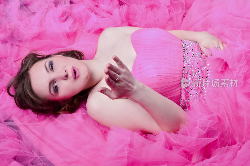 身着粉裙躺卧的女性