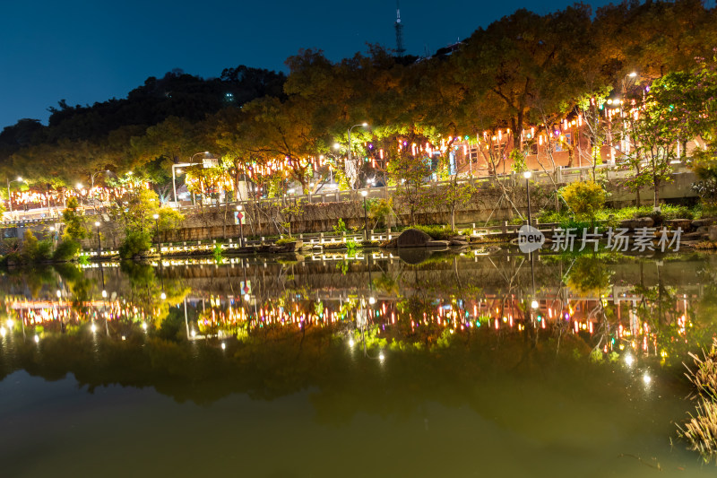 夜晚城市公园湖面倒映的璀璨灯光