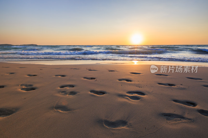 日落金色沙滩的足迹