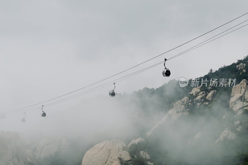 山间缆车穿行于云雾缭绕的山景中