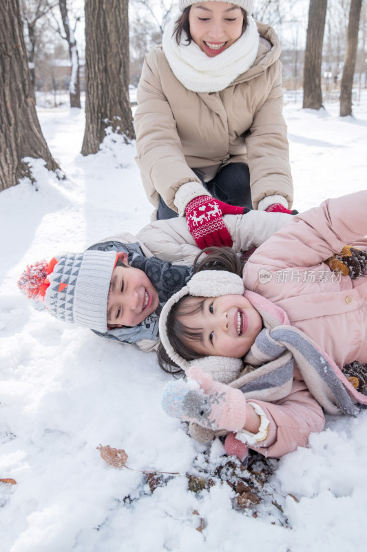 年轻妈妈和孩子们在雪地里玩耍