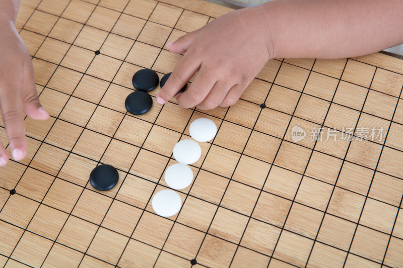 小手拿着棋子在围棋棋盘上下棋