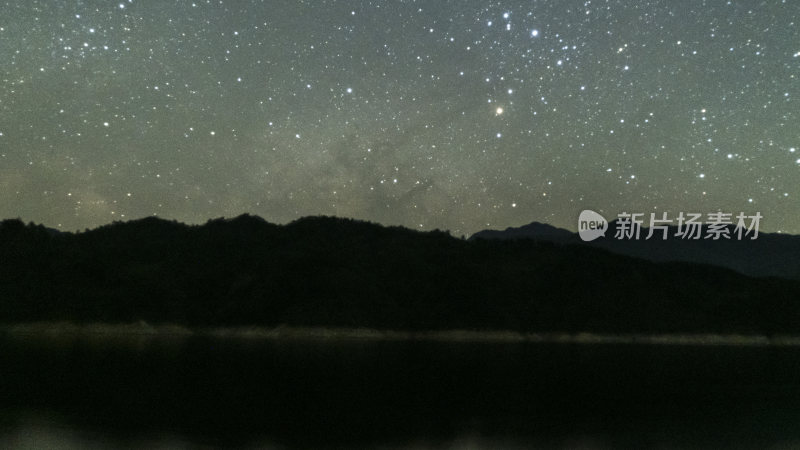 繁星密布的夜空下的山峦与湖水