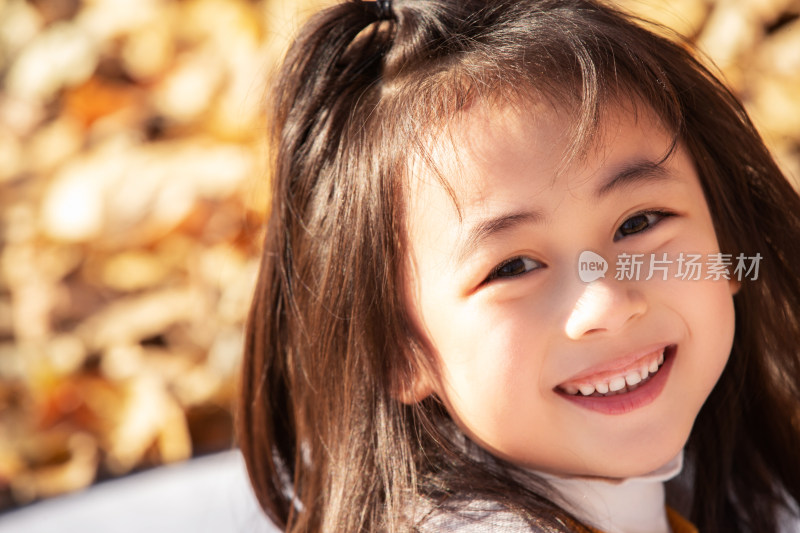 户外秋天可爱的小女孩在微笑