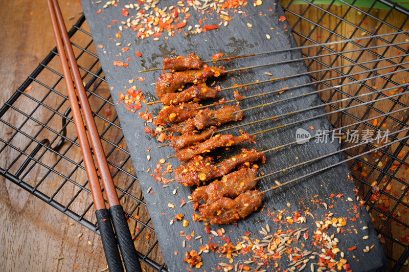 手持撒料的烤肉串特写