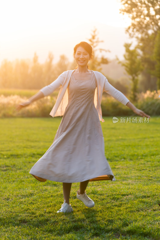 一个女人在草地上开心的舞蹈