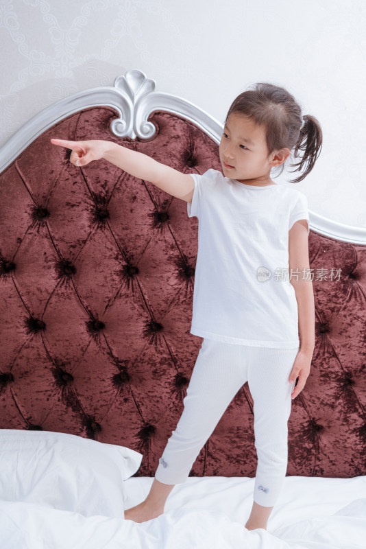 穿着白色衣服在床上玩耍的中国女孩