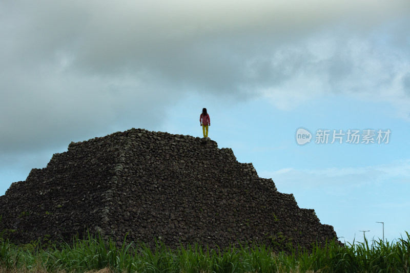 远处一个孤独男人站在巨大石堆上的背影