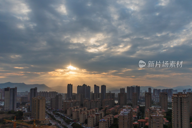 城市建筑群上空云层中的日出景象