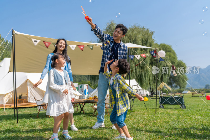 一家人在露营地天幕下玩耍