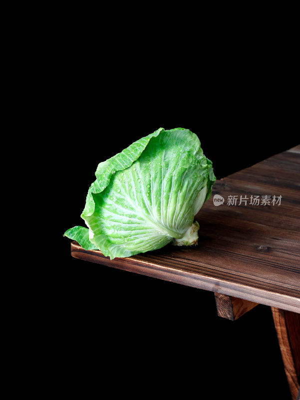 木桌角上摆放着一个绿色蔬菜包菜卷心菜