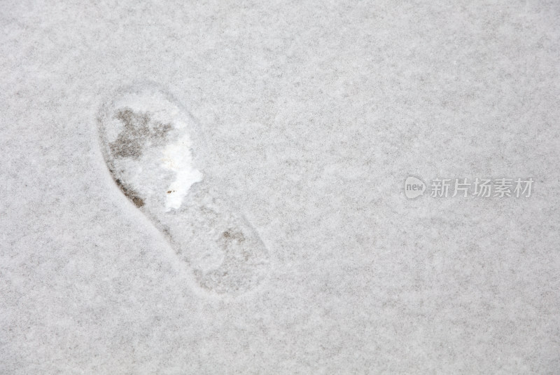 地面上刚下的雪和一个脚印