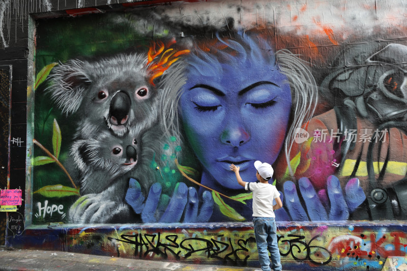 澳大利亚墨尔本涂鸦街涂鸦墙前的小男孩