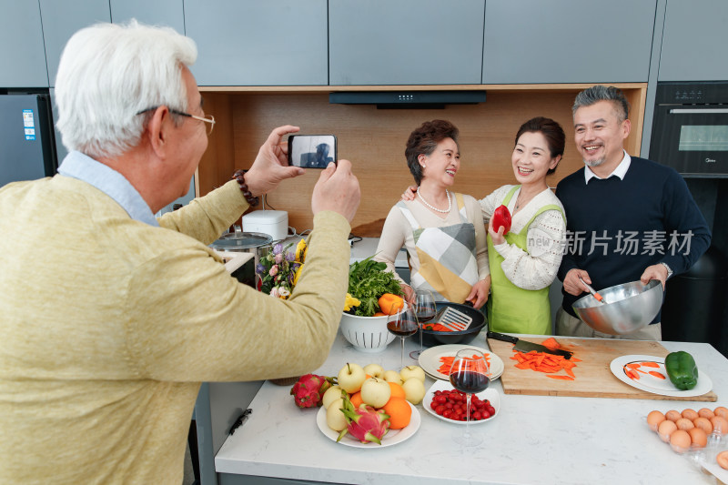 老年朋友们边做饭边照相