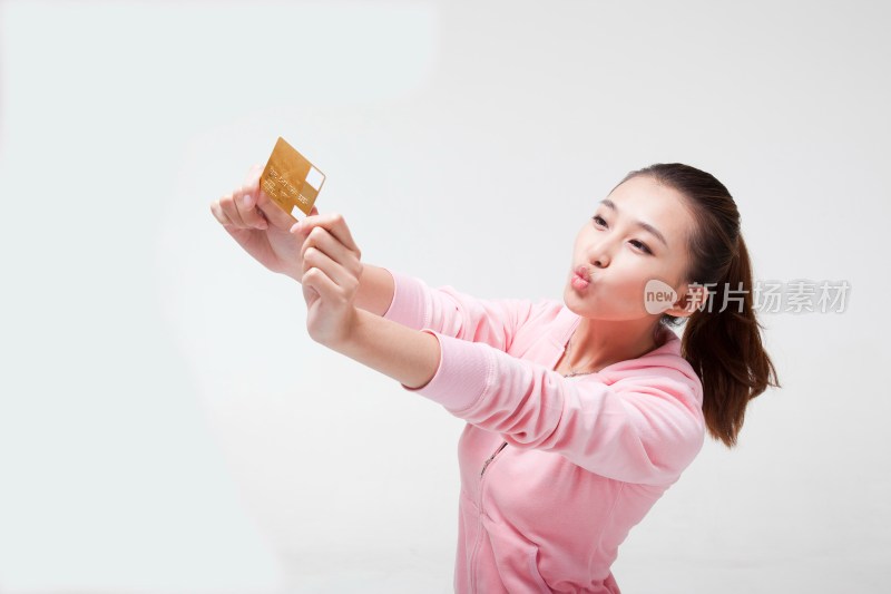 快乐的年轻女人拿着信用卡