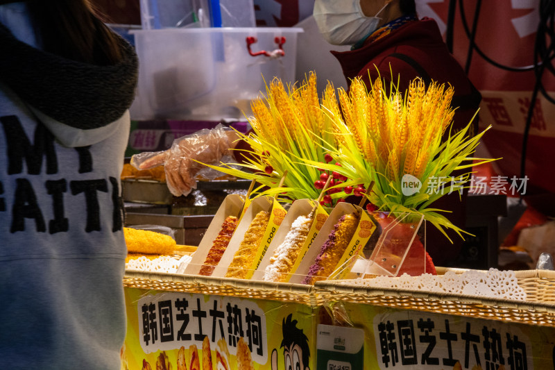 夜晚小吃街摊贩正在为顾客制作芝士热狗