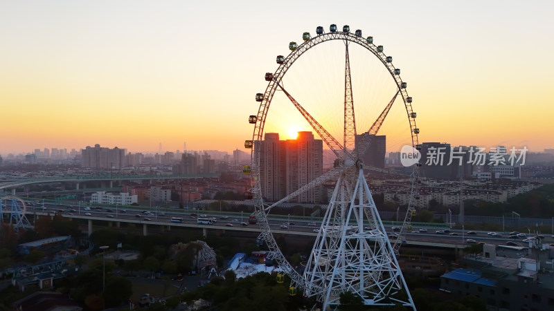 夕阳下城市中的摩天轮全景