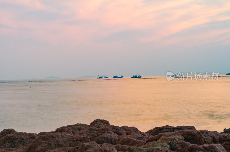 夕阳下，天际线上有轮船驶过