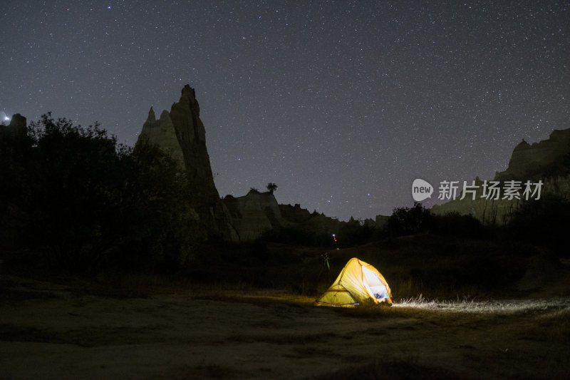 野外露营帐篷置于云南土林夜色地貌中的景象