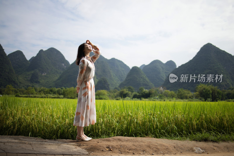 美丽的年轻女子在桂林旅行 站在稻田里