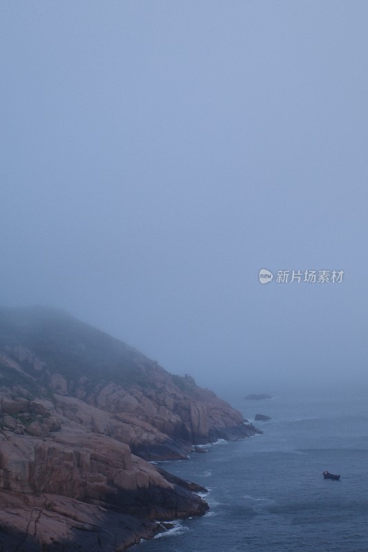 雾霭中海边礁石的宁静景象