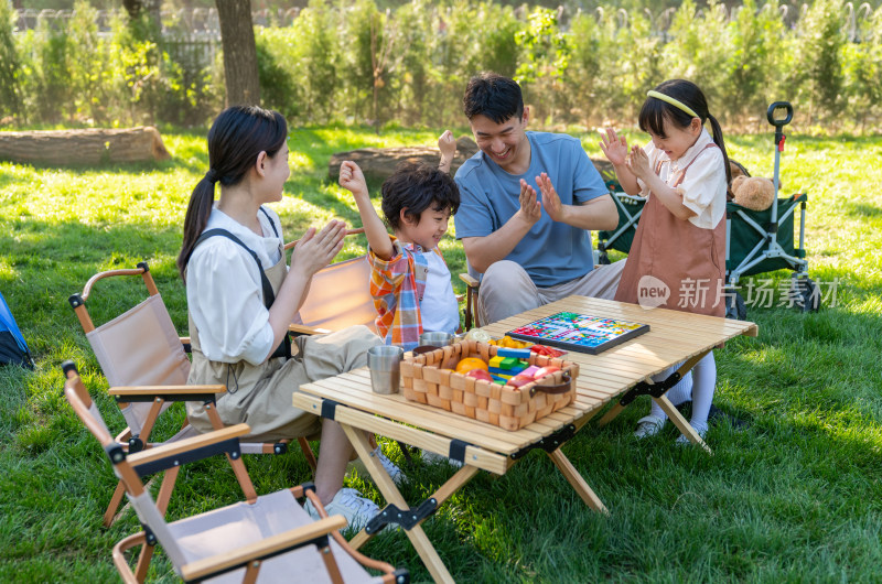 一家四口在露营地玩游戏开心欢呼庆祝