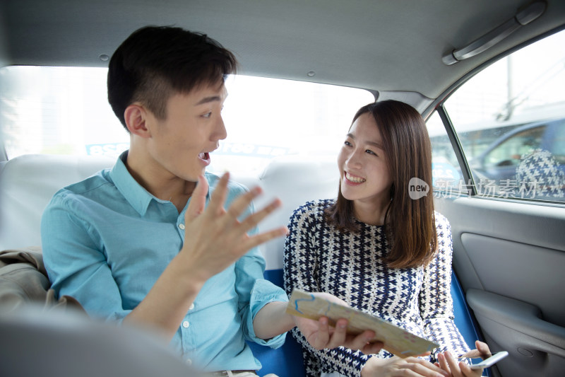 青年情侣在车内看地图