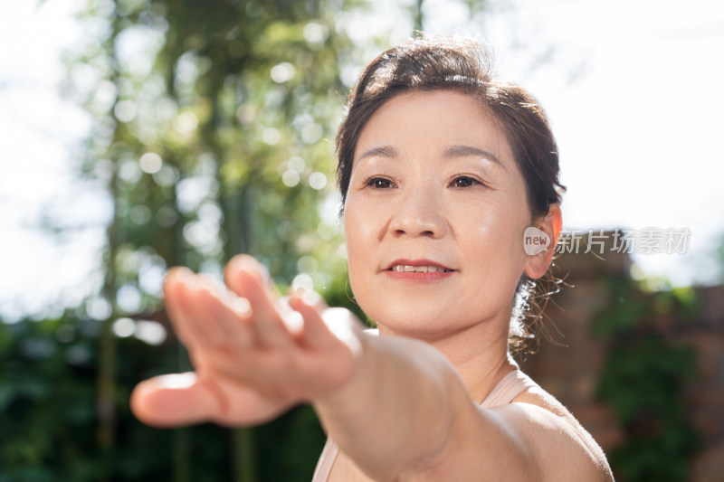 快乐的中老年女士在户外练瑜伽