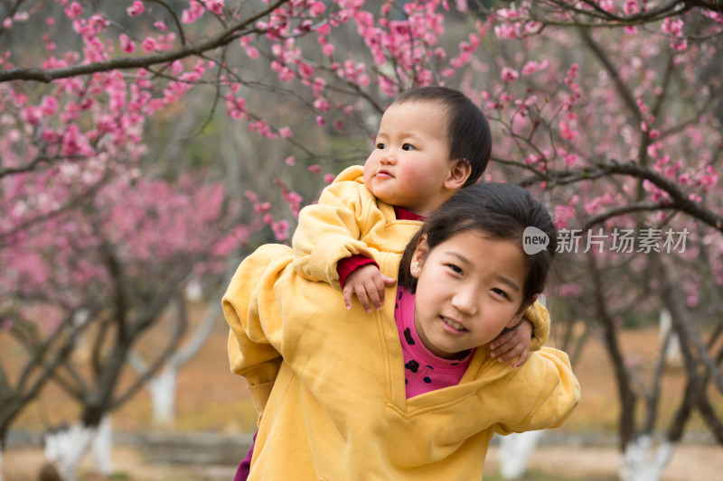 姐姐背着妹妹赏花玩耍