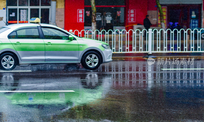 一辆绿色的出租车在雨天中行驶