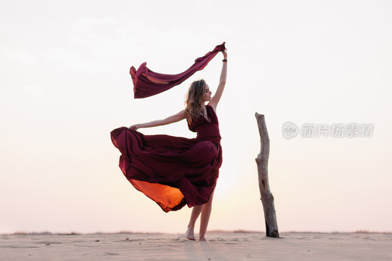 沙滩上女子舞动红裙