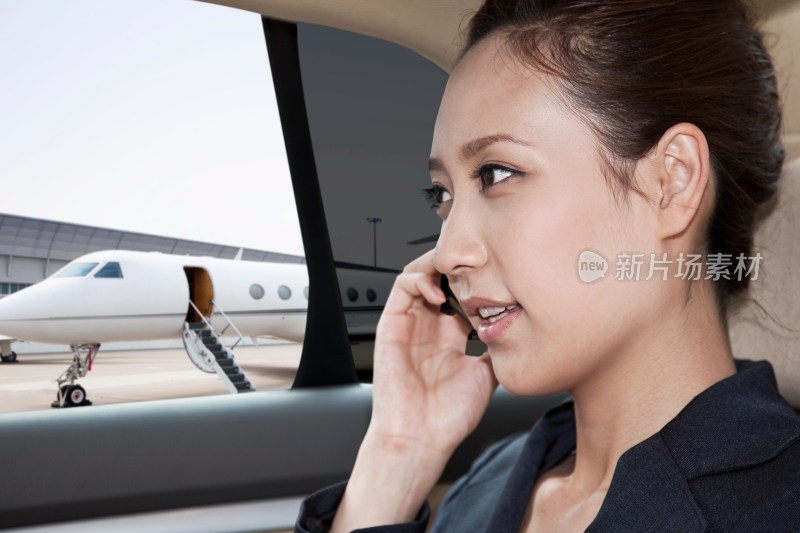 商务女士坐在轿车里打手机