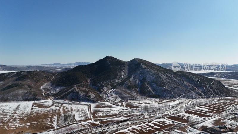 冬季山地景象，山坡与田地覆盖着积雪