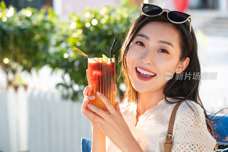 快乐的青年女人端着夏日饮品