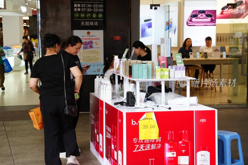 商场内顾客查看促销摊位