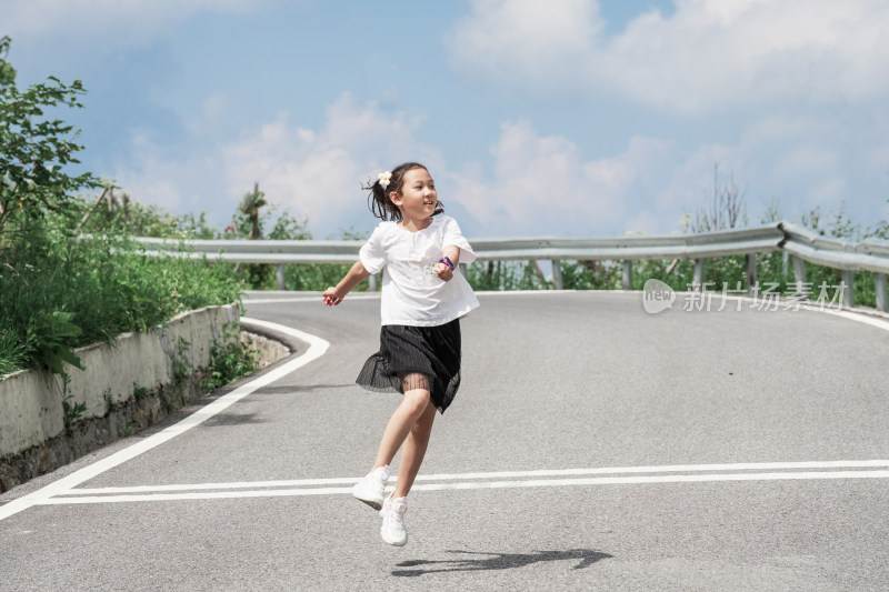 晴朗的夏天午后走在盘山公路上的东方女孩