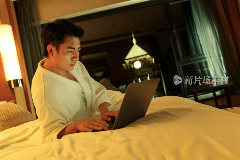 青年男人在酒店客房里使用电脑