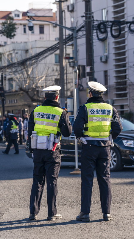 两名公安辅警站在街道上执勤