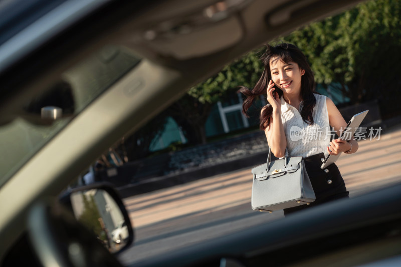 打电话的青年女人走向汽车