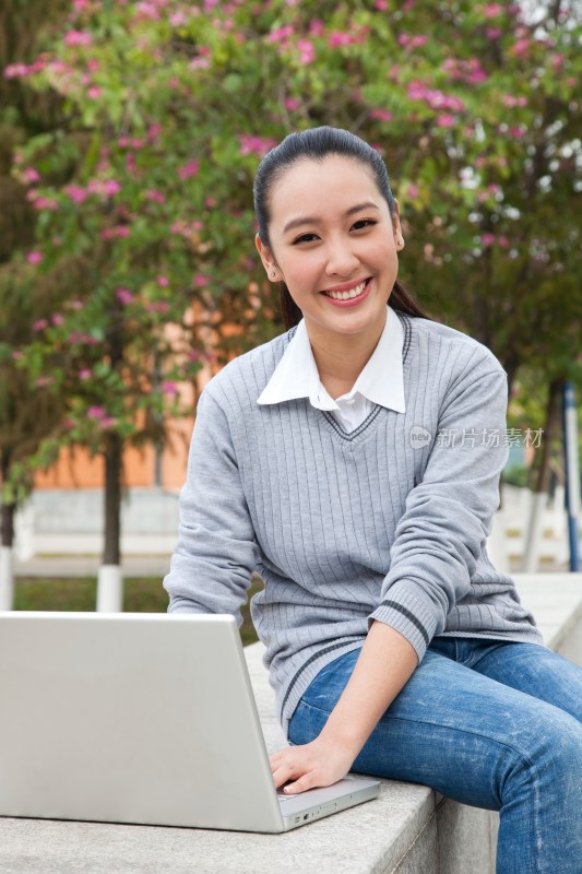 年轻大学生在校园里使用笔记本电脑