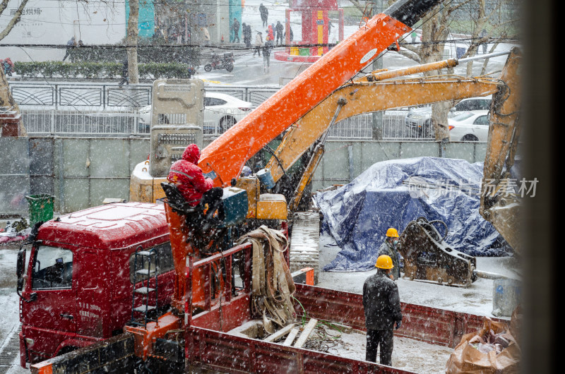 风雪中在卡车上施工的工人