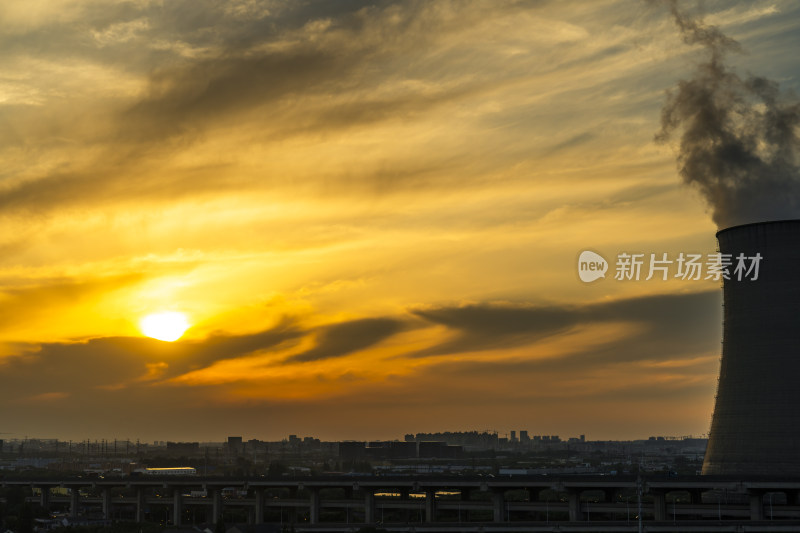 夕阳下冒着烟的冷却塔景象