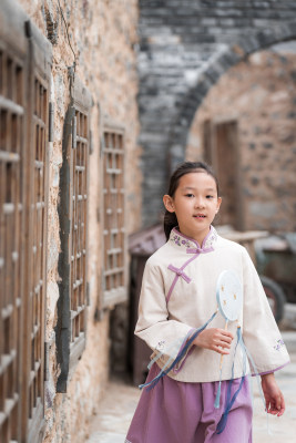 穿中国传统服饰走在古院落街道上的女孩