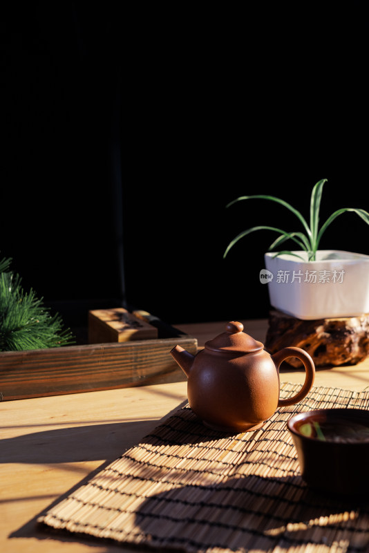 午后阳光照在摆着紫砂壶的木质桌子上