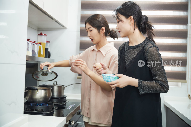 在厨房烹饪美食的亚洲闺蜜少女